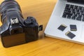 Digital camera, Laptop and memory card on wood table. With copy space for text or design Royalty Free Stock Photo