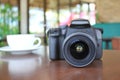 Digital camera of photographer on wooden table in coffee shop Royalty Free Stock Photo