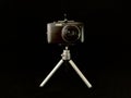 Digital camera with a small lens on a black background. Concept: home photo shooting, equipment Royalty Free Stock Photo