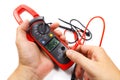 Digital clamp multimeter with probes in man`s hand on a white background Royalty Free Stock Photo