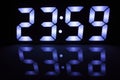 Digital Clock Display Showing 23:59 with Blue LED Glow and Reflection Royalty Free Stock Photo