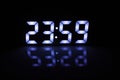 Digital Clock Display Showing 23:59 with Blue LED Glow and Reflection Royalty Free Stock Photo