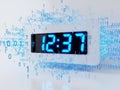 Digital clock displaying time amidst a digital binary data backdrop Royalty Free Stock Photo