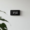 Digital clock with a rectangular black display shows the time as 12:00 in white numerals. Royalty Free Stock Photo