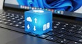Digital cloud computing cube symbolizing data storage and transfer on a laptop keyboard Royalty Free Stock Photo