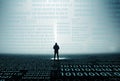 A digital code concept of a lone hooded figure looking at numbers on a misty night Royalty Free Stock Photo