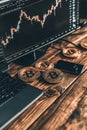Digital Coins with Chart Display next to Laptop keyboard for Cryptocurrency Trading on Table Royalty Free Stock Photo