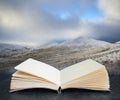 Digital composite of Beautiful landscape of snow covered mountains during late afternoon in Winter in pages of open book Royalty Free Stock Photo