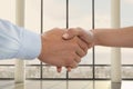 Business people shaking hands against office background Royalty Free Stock Photo