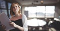 Confused business woman holding files against office background