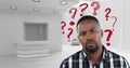 Confused man in a white office with red question marks Royalty Free Stock Photo