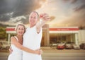 Couple Holding key in front of cars Royalty Free Stock Photo