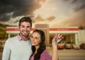 Couple Holding key in front of cars Royalty Free Stock Photo