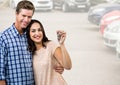 Couple Holding key in front of cars Royalty Free Stock Photo