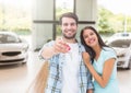 Couple Holding key in front of cars Royalty Free Stock Photo