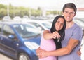 Couple Holding key in front of cars Royalty Free Stock Photo