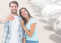 Couple Holding key in front of cars Royalty Free Stock Photo