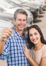 Couple Holding key in front of cars Royalty Free Stock Photo