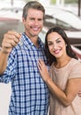 Couple Holding key in front of cars Royalty Free Stock Photo