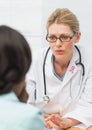 Doctor woman with breast cancer awareness ribbon and patient Royalty Free Stock Photo