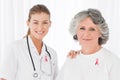 Doctor woman and patient with breast cancer awareness ribbons Royalty Free Stock Photo