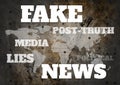 Fake news and associated text over world map grunge background Royalty Free Stock Photo