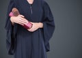 Female judge mid section with book and gavel against grey background Royalty Free Stock Photo