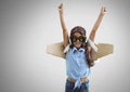 Girl against grey background with cardboard pilot wings