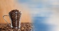 Glass coffee cup full of beans with blurry sky transition Royalty Free Stock Photo