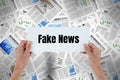 Hands holding card with Fake news against 3d newspapers Royalty Free Stock Photo