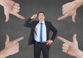 Hands pointing at business man against grey background Royalty Free Stock Photo