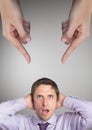 Hands pointing at surprised business man against grey background Royalty Free Stock Photo