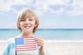 Happy boy holding a USA flag in the beach Royalty Free Stock Photo