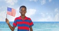 Happy boy holding a USA flag in the beach Royalty Free Stock Photo