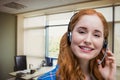 Happy customer care representative woman against office background Royalty Free Stock Photo