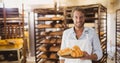 Happy small business owner man holding croissants