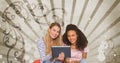 Happy young students holding a tablet against brown and white splattered background