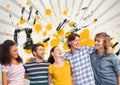 Happy young students standing against grey, yellow and black splattered background Royalty Free Stock Photo