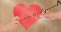 Heart beat over hands holding heart Royalty Free Stock Photo