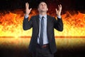 Digital composite image of angry businessman with fire in background Royalty Free Stock Photo