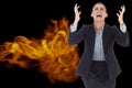 Digital composite image of angry businesswoman screaming with fire in background