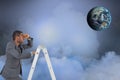 Digital composite image of businessman on ladder looking at globe in sky Royalty Free Stock Photo