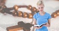 Digital composite image of caucasain young woman reading bible with rosary on book in background Royalty Free Stock Photo
