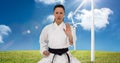 Digital composite image of caucasian female marital artist with black belt against wind mills Royalty Free Stock Photo