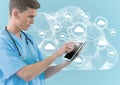 Digital composite image of doctor using digital tablet against cloud computing icons Royalty Free Stock Photo