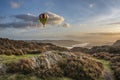 Digital composite image of hot air balloons over Majestic Autumn sunset landscape image from Holme Fell looking towards Coniston Royalty Free Stock Photo