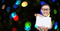 Digital composite image of nerd pointing at placard against colorful lights Royalty Free Stock Photo