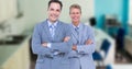 Digital composite image of smiling businessmen with arms crossed against office Royalty Free Stock Photo