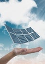 Digital composite image of solar panel on hand against sky