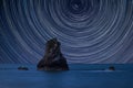 Digital composite image of star trails around Polaris with Beautiful conceptual long exposure peaceful landscape of rocks in sea Royalty Free Stock Photo